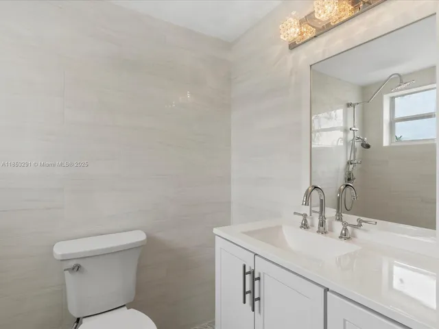 a bathroom with a sink mirror vanity and toilet
