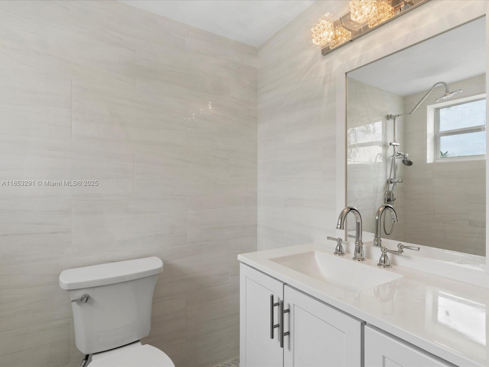 200 Northeast 12th Avenue, Unit 7C Hallandale Beach, FL 33009 - Photo 11 of 27 a bathroom with a sink mirror vanity and toilet