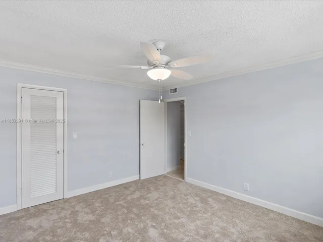 an empty room with a ceiling fan and a window