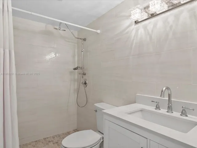a bathroom with a granite countertop toilet sink and shower