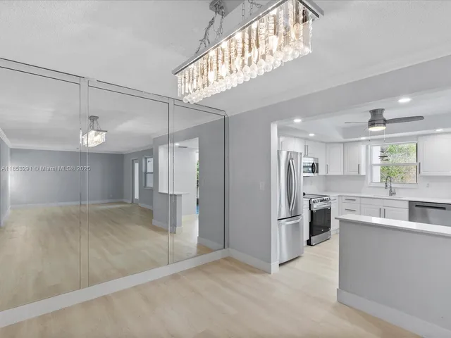 a view of a kitchen with refrigerator and cabinets