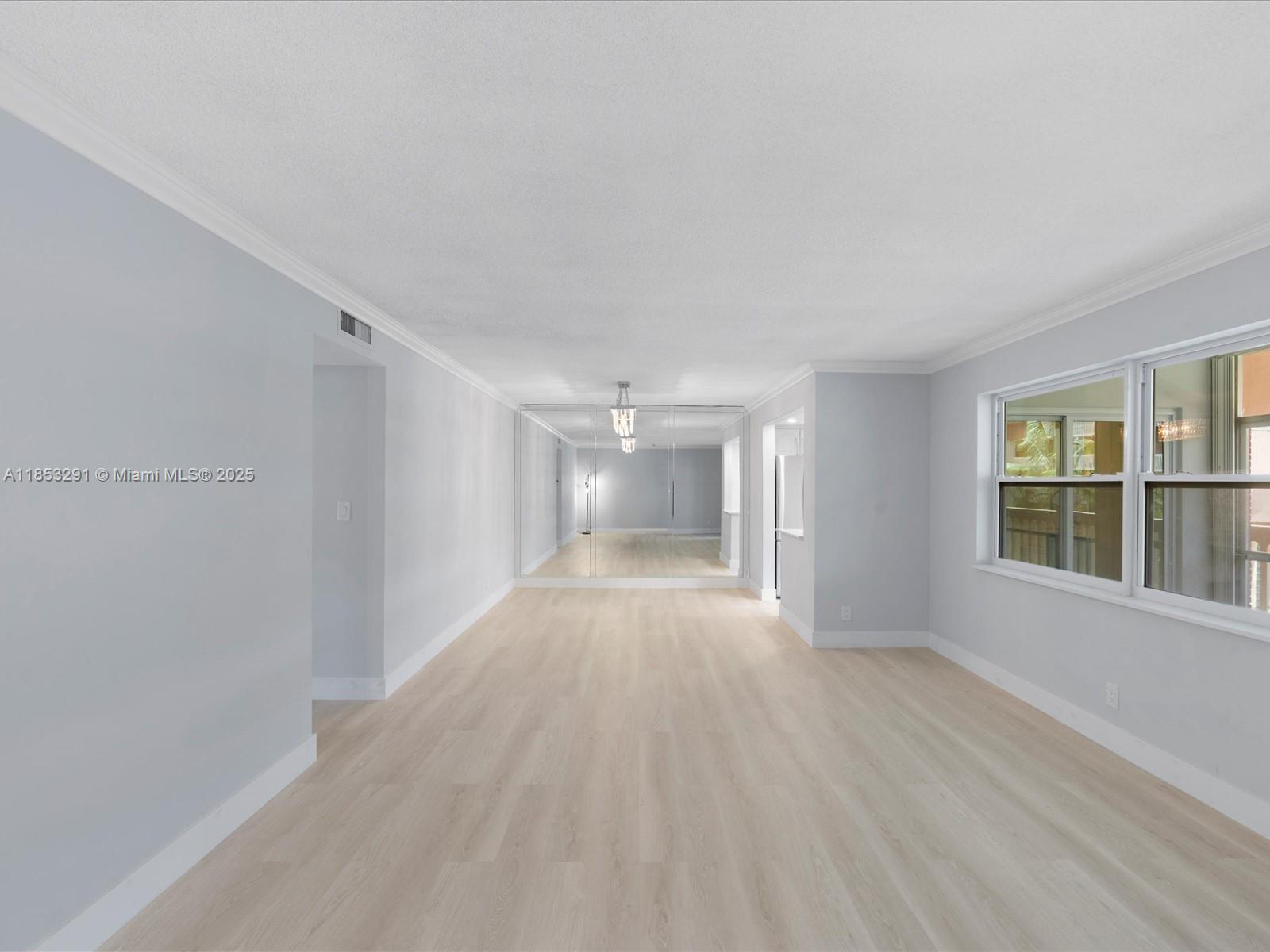 200 Northeast 12th Avenue, Unit 7C Hallandale Beach, FL 33009 - Photo 9 of 27 a view of an empty room with a window and wooden floor