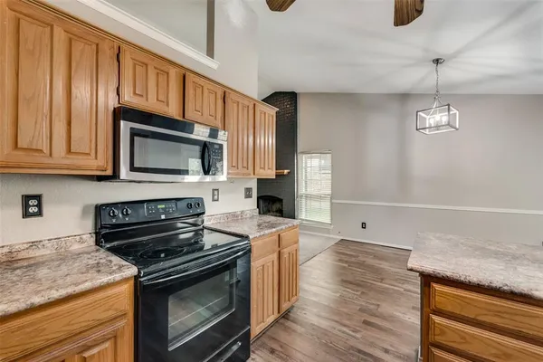 a kitchen with stainless steel appliances granite countertop a stove microwave and cabinets