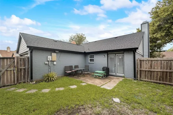 a backyard of a house with table and chairs
