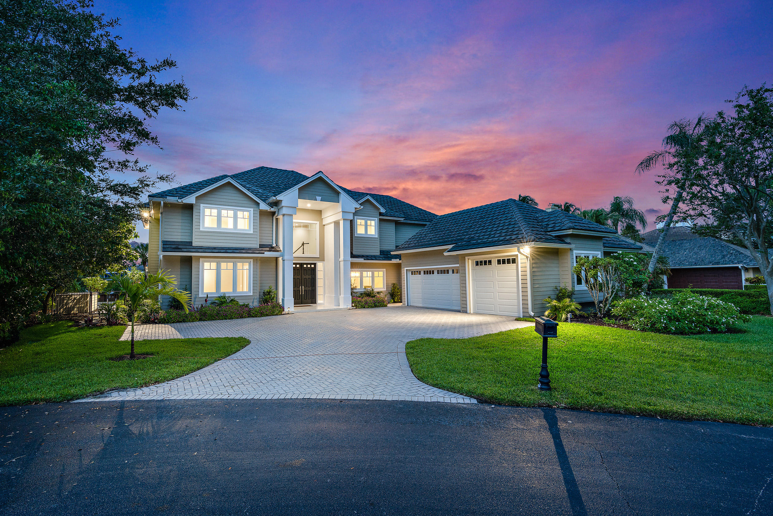 18169 Southeast Ridgeview Drive Tequesta, FL 33469 - Photo 2 of 51 a front view of a house with a yard and garage