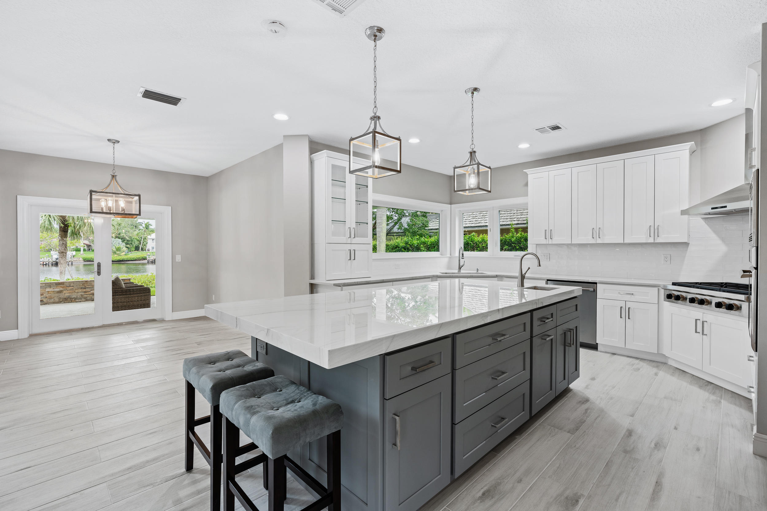 18169 Southeast Ridgeview Drive Tequesta, FL 33469 - Photo 13 of 51 a kitchen with kitchen island granite countertop a stove a sink a center island and windows