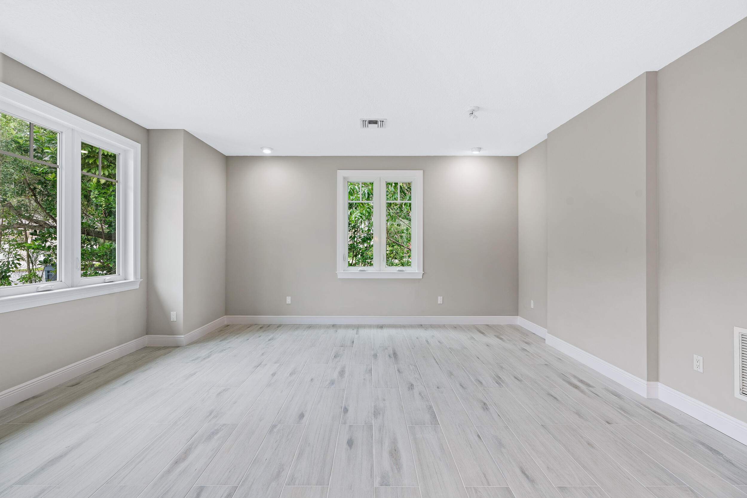 18169 Southeast Ridgeview Drive Tequesta, FL 33469 - Photo 18 of 51 a view of an empty room with wooden floor and a window