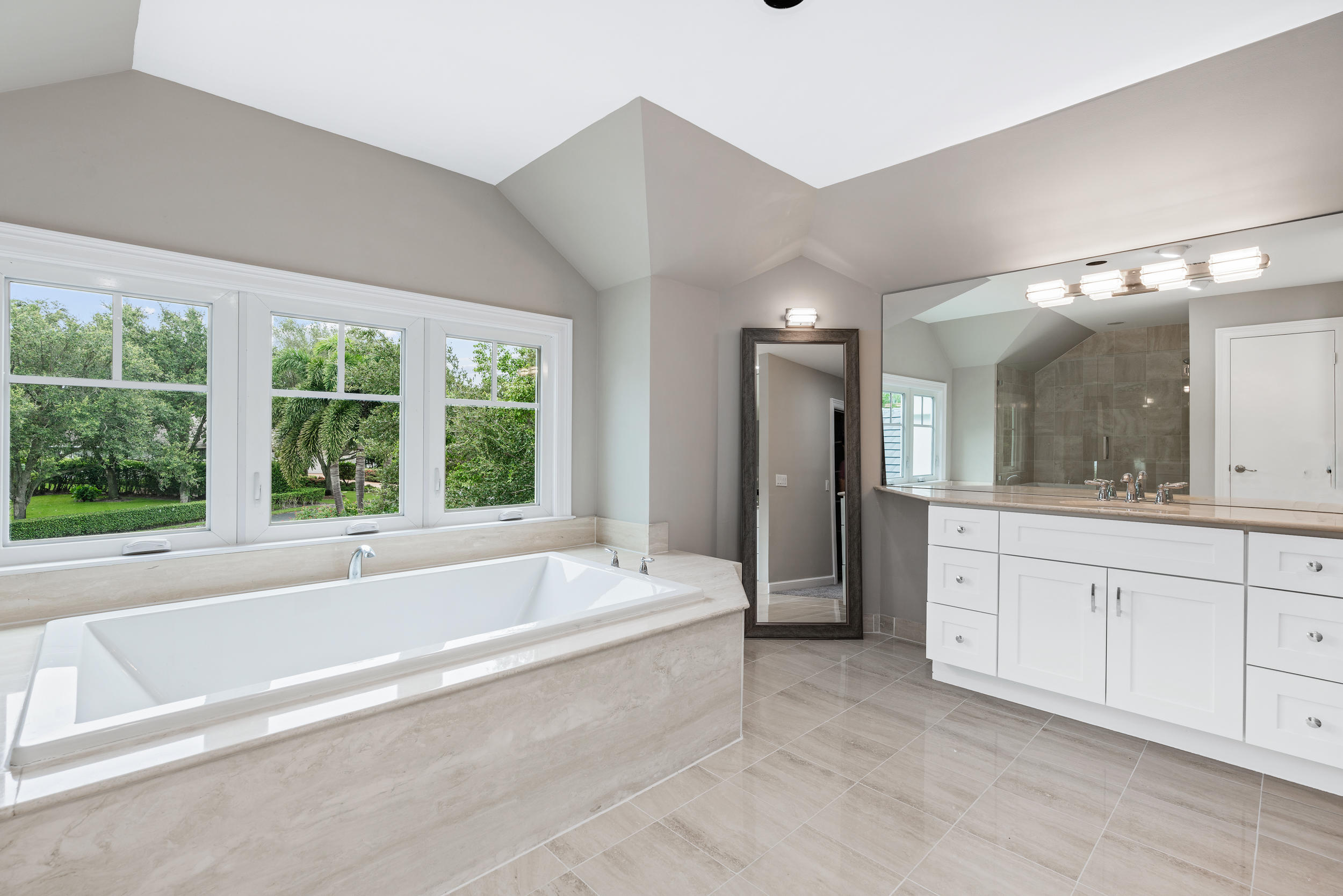 18169 Southeast Ridgeview Drive Tequesta, FL 33469 - Photo 24 of 51 a spacious bathroom with a tub sink and mirror