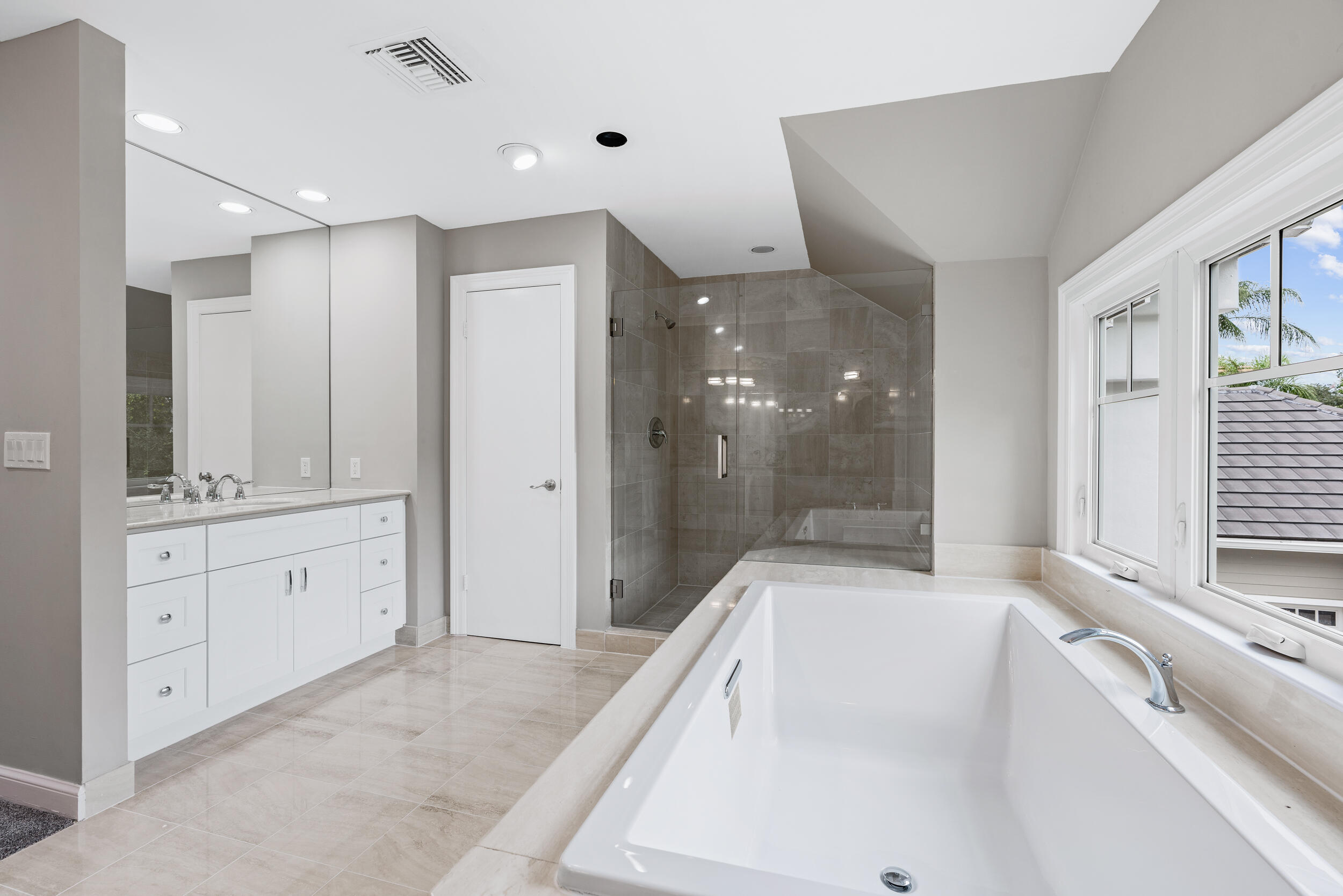 18169 Southeast Ridgeview Drive Tequesta, FL 33469 - Photo 25 of 51 a spacious bathroom with a granite countertop tub shower double vanity and a sink