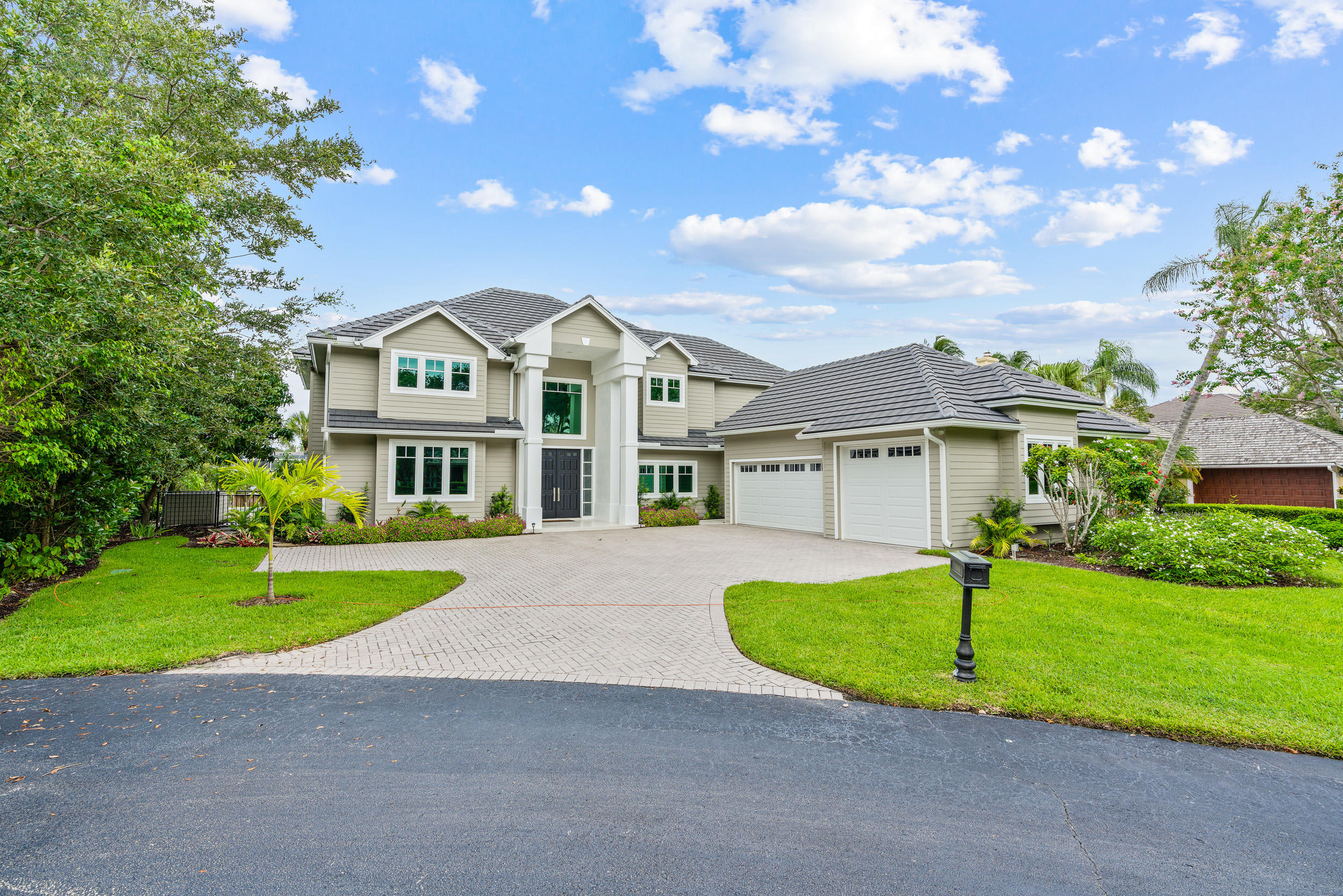 18169 Southeast Ridgeview Drive Tequesta, FL 33469 - Photo 7 of 51 a front view of a house with a yard and garage