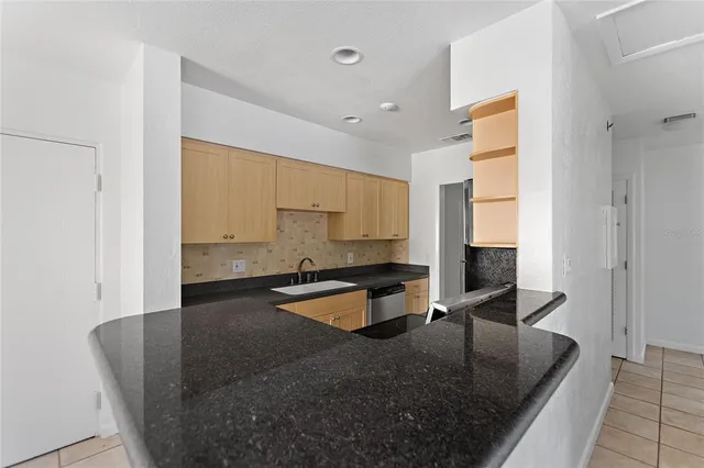 a large kitchen with kitchen island stainless steel appliances a sink stove and cabinets
