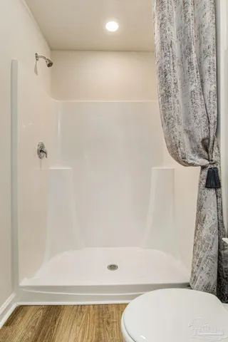 a bathroom with a toilet and a shower