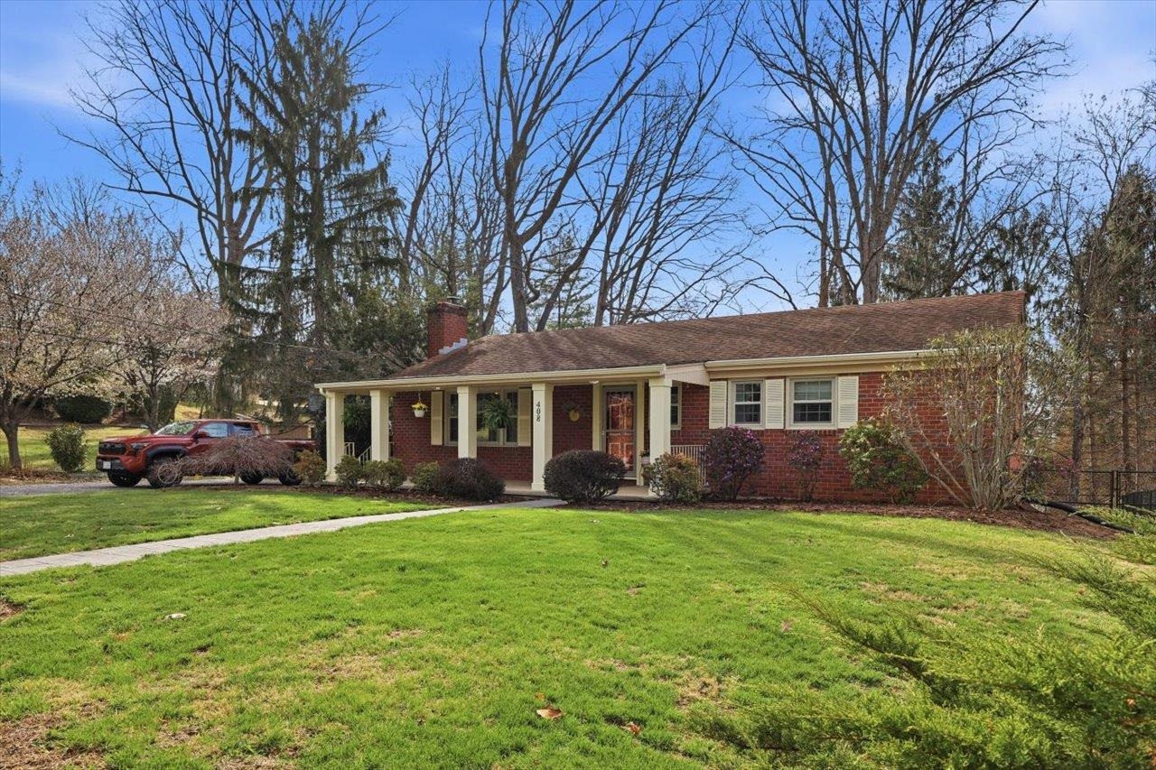 a view of a house with a yard and trees