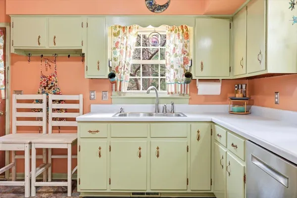 a kitchen with cabinets appliances and a large window