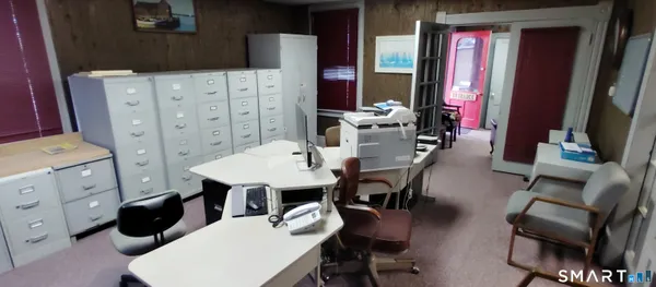 a living room with furniture a flat screen tv and kitchen view