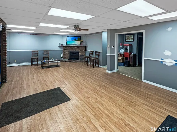 a living room with stainless steel appliances furniture a fireplace and a flat screen tv