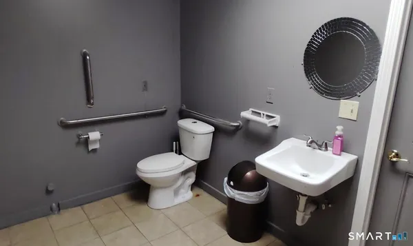 a white toilet sitting next to a bathroom sink and a mirror