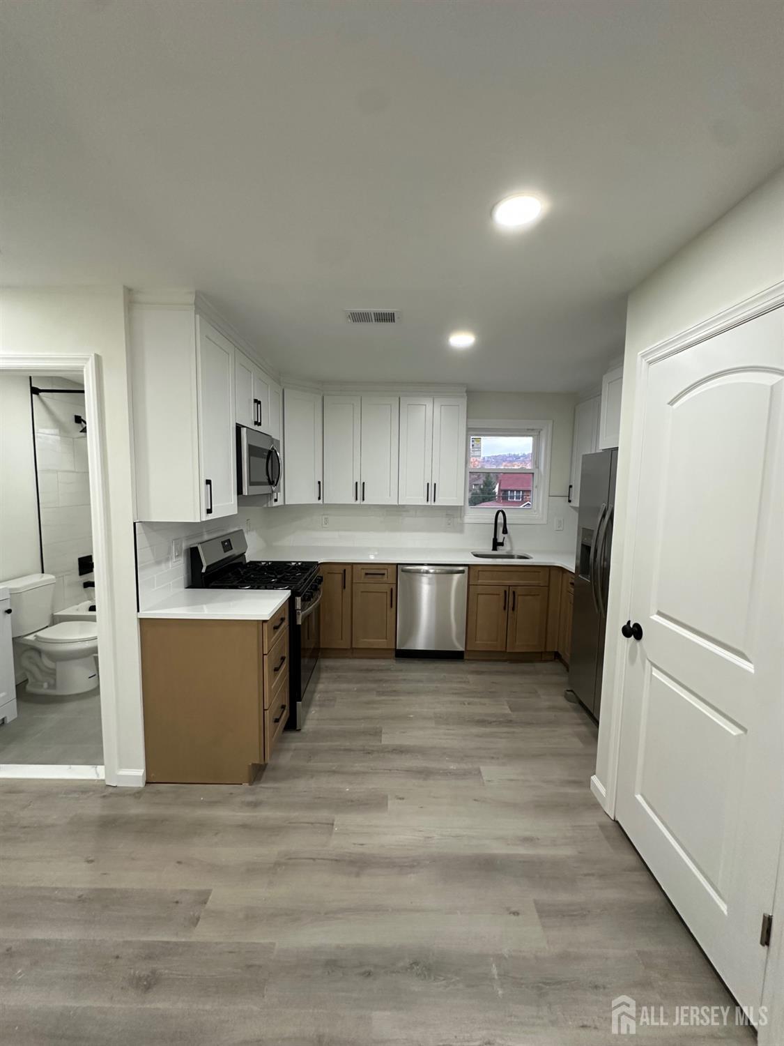 112 Fairview Avenue, Unit 2 Middlesex, NJ 08846 - Photo 11 of 29 a large kitchen with a refrigerator a stove top oven a counter space and cabinets