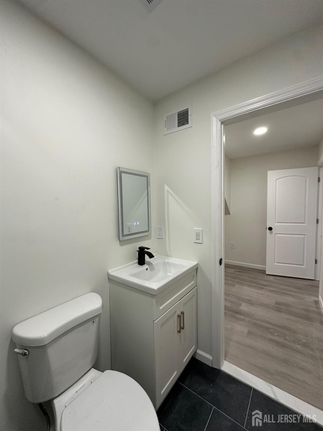 112 Fairview Avenue, Unit 2 Middlesex, NJ 08846 - Photo 25 of 29 a bathroom with a toilet sink and mirror