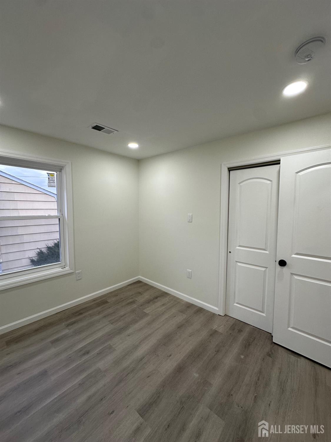 112 Fairview Avenue, Unit 2 Middlesex, NJ 08846 - Photo 7 of 29 a view of an empty room with wooden floor and a window