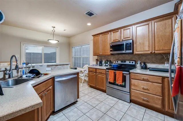 a kitchen with a sink dishwasher and cabinets with wooden floor