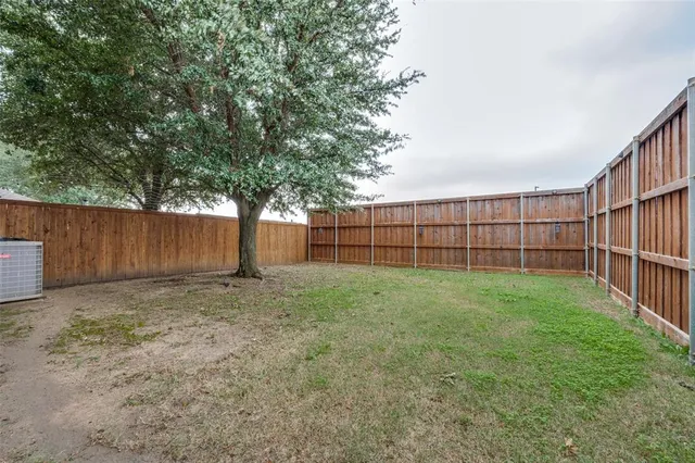 a fire hydrant in front of a yard with wooden fence