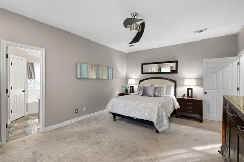 a spacious bedroom with a bed and a chandelier