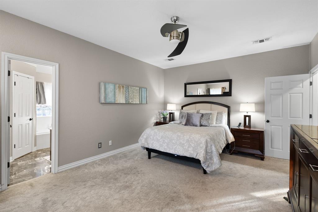 1701 Oakmeadow Drive Decatur, TX 76234 - Photo 15 of 39 a spacious bedroom with a bed and a chandelier
