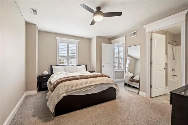 a bedroom with a large bed couch and a window