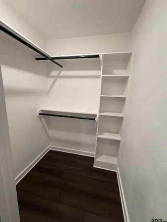 a view of walk in closet with empty racks