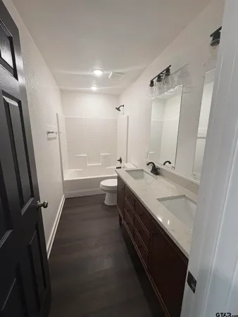 a bathroom with double vanity and a mirror
