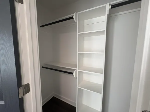 a view of walk in closet with empty racks