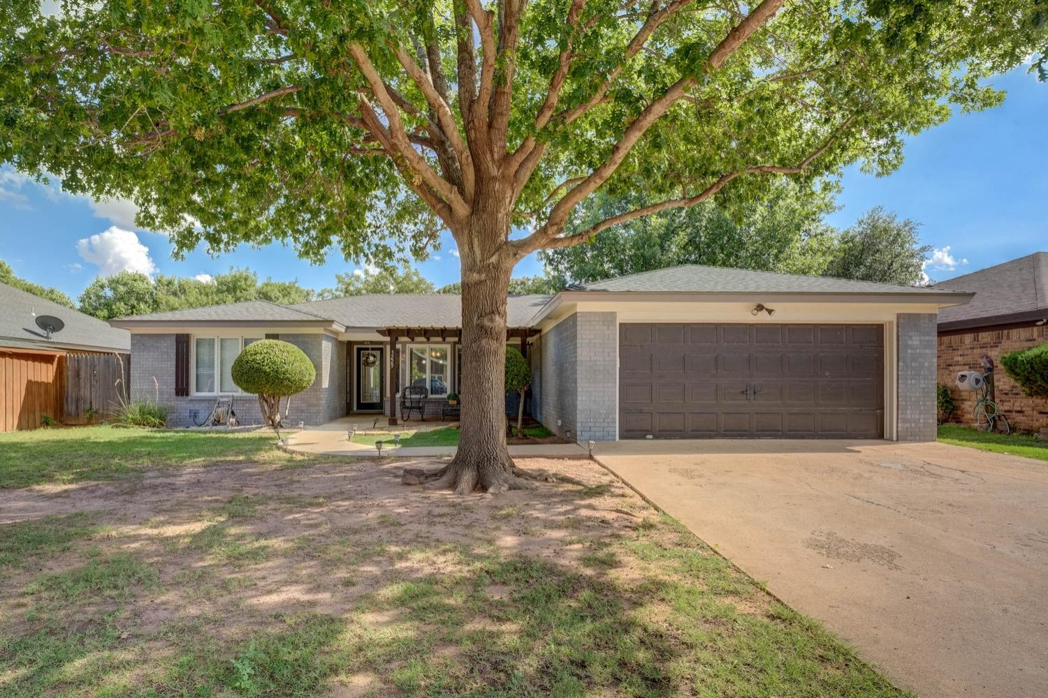 5229 91st Street Lubbock, TX 79424 - Photo 1 of 28 a front view of a house with a yard and garage