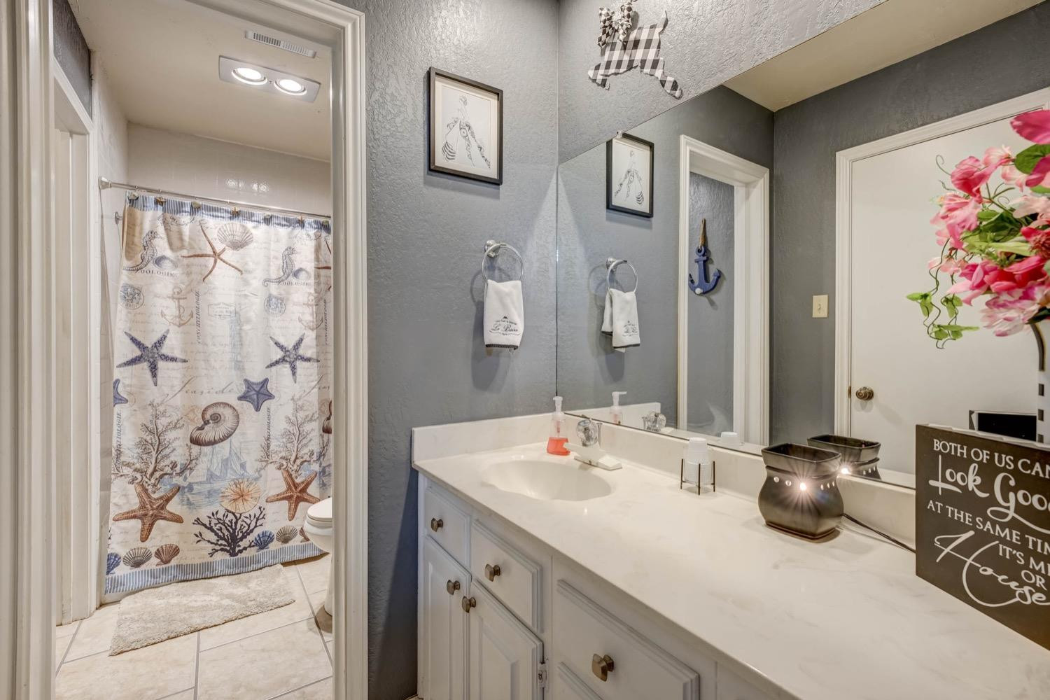 5229 91st Street Lubbock, TX 79424 - Photo 20 of 28 a bathroom with a sink mirror and vanity