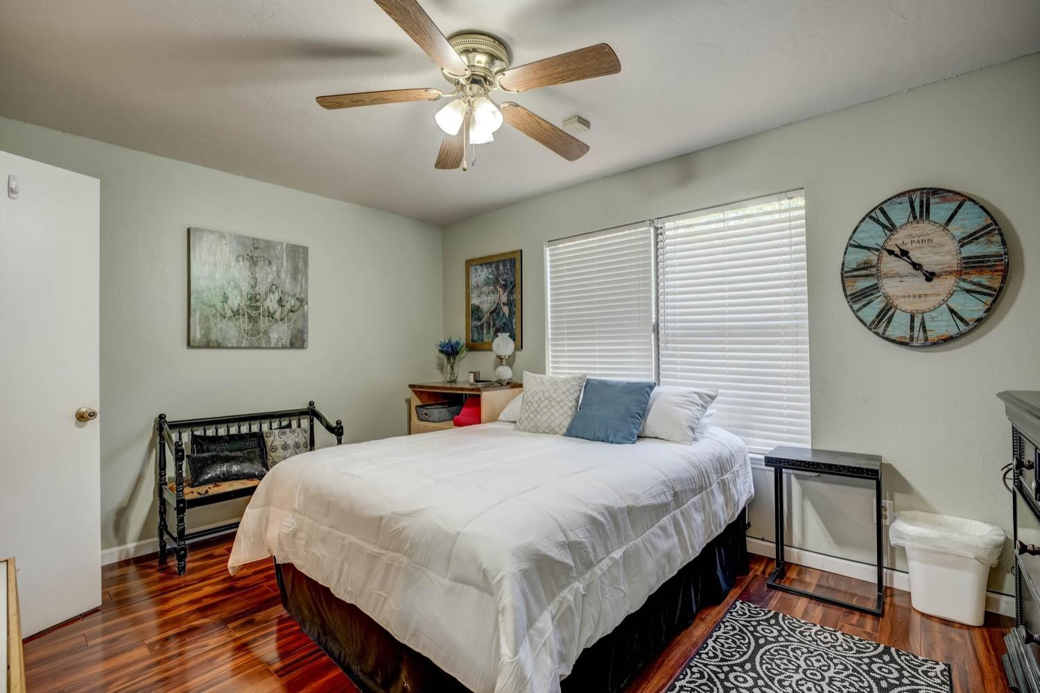 5229 91st Street Lubbock, TX 79424 - Photo 21 of 28 a bedroom with a bed a clock on the wall and a table