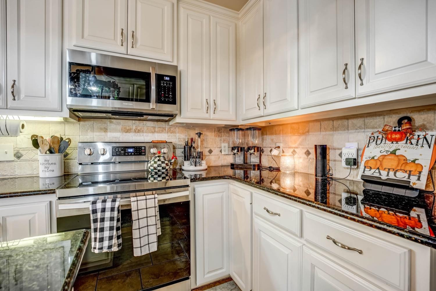 5229 91st Street Lubbock, TX 79424 - Photo 9 of 28 a kitchen with stainless steel appliances granite countertop a stove and cabinets