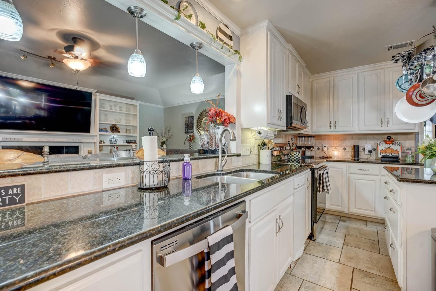 5229 91st Street Lubbock, TX 79424 - Photo 10 of 28 a kitchen with stainless steel appliances granite countertop a sink stove and cabinets