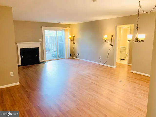 a view of a livingroom with wooden floor and a fireplace