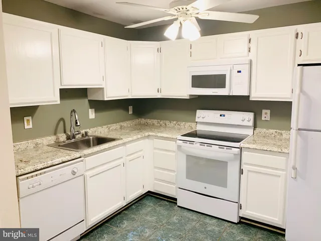 a kitchen with cabinets appliances a sink and a counter top space
