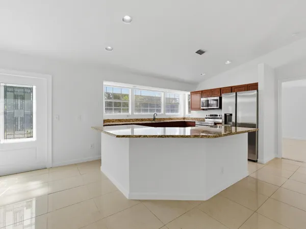 a kitchen with stainless steel appliances granite countertop a sink and a stove