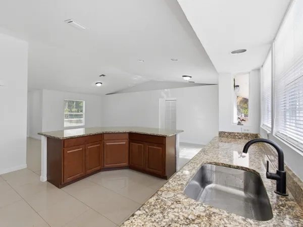 a kitchen with stainless steel appliances granite countertop a sink a stove and a wooden cabinets