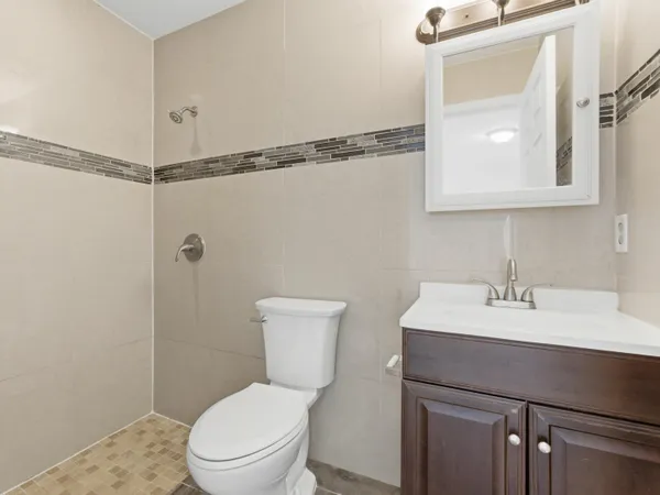 a bathroom with a toilet a sink and mirror