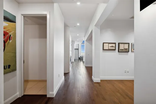 a view of a hallway with wooden floor and closet