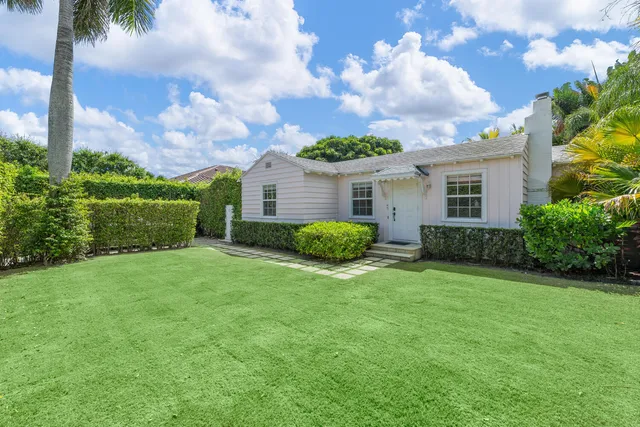 a view of a house with a yard and potted plants