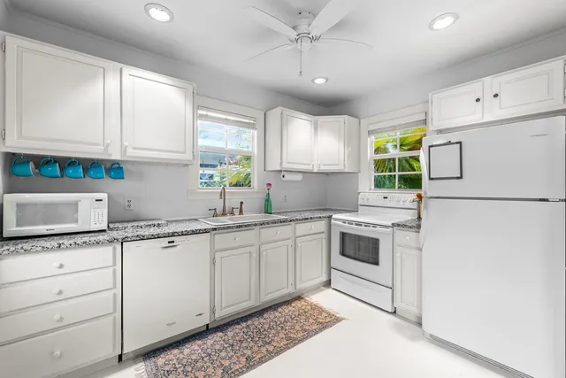 a bedroom with a bed a mirror and a large window