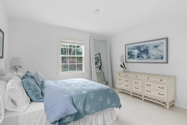 a large bed sitting in a bedroom next to a window