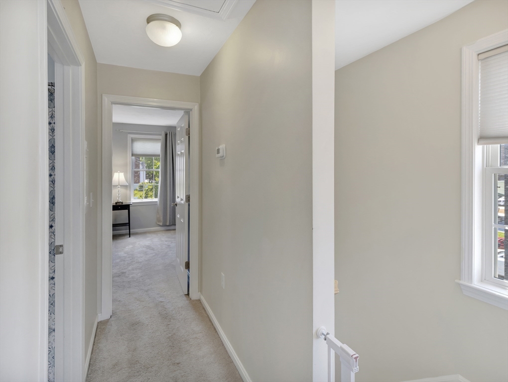 13 Shawmut Avenue, Unit 13 Mansfield, MA 02048 - Photo 23 of 34 a view of a hallway with wooden floor and a living room
