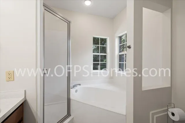 a bathroom with a tub sink and mirror