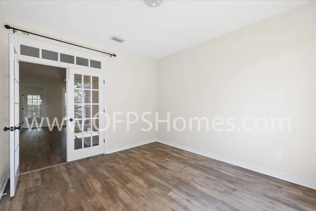 view of an empty room with wooden floor and a window