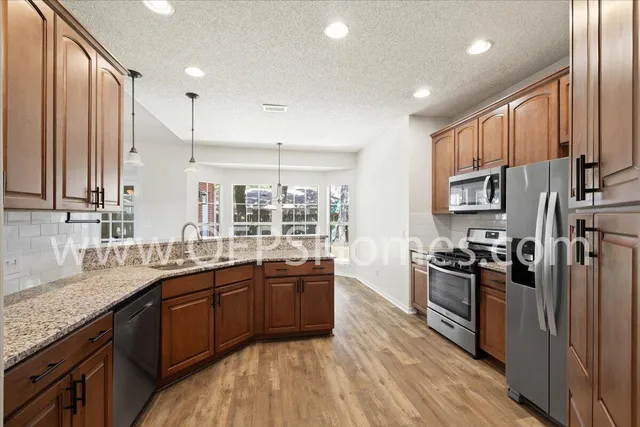 a kitchen with stainless steel appliances granite countertop a sink stove and refrigerator